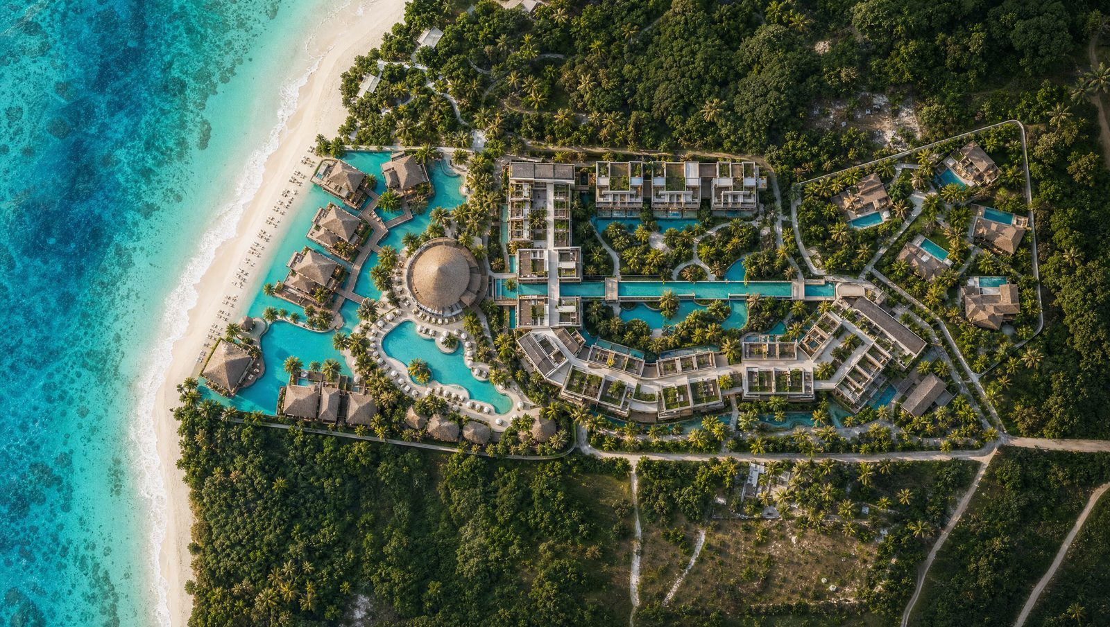 Aerial view of the resort: hotel buildings with pools on the first line of the beach